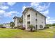 Side angle of condo with multiple floors of balconies and beautiful green grass and landscaping at 673 Tupelo Ln. # G, Longs, SC 29568
