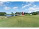 Scenic golf course view with a red flag, lush greenery, and a water hazard at 673 Tupelo Ln. # G, Longs, SC 29568