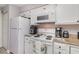 Well-lit kitchen with white appliances and cabinets, as well as warm countertops at 673 Tupelo Ln. # G, Longs, SC 29568