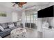 Cozy living room with gray couches, sliding glass doors to balcony, and ceiling fan at 673 Tupelo Ln. # G, Longs, SC 29568