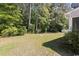Grassy backyard featuring mature trees and privacy fence at 680 Twinflower St., Little River, SC 29566