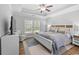 A primary bedroom with tray ceilings, a ceiling fan, and windows overlooking the yard at 680 Twinflower St., Little River, SC 29566