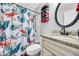 Bright bathroom with a flamingo shower curtain, a round mirror, and granite countertop at 6864 Woodhaven Dr., Myrtle Beach, SC 29588