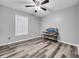 A bright bedroom with modern floors, ceiling fan, and a console table at 6864 Woodhaven Dr., Myrtle Beach, SC 29588