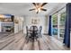 Bright dining room features wood floors, a ceiling fan, a brick fireplace, and sliding glass doors to the patio at 6864 Woodhaven Dr., Myrtle Beach, SC 29588