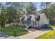 Landscaped exterior with a quaint covered porch, inviting entryway, and spacious driveway, complete with parking at 6864 Woodhaven Dr., Myrtle Beach, SC 29588