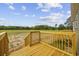 Backyard featuring an unseeded lawn, a wooden deck, and trees surrounding the perimeter at 7019 Norton Rd., Green Sea, SC 29545