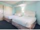 Bedroom with two queen beds, bright turquoise walls, and closet providing a comfortable space at 7100 N Ocean Blvd. # 621, Myrtle Beach, SC 29572