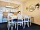 Charming dining area with a white table, blue cushioned chairs, and stylish decor at 7100 N Ocean Blvd. # 621, Myrtle Beach, SC 29572