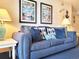 Comfortable blue sofa with decorative pillows, complemented by beach-themed art and pineapple lamp at 7100 N Ocean Blvd. # 621, Myrtle Beach, SC 29572