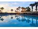 Relaxing pool area with lounge chairs, palm trees, and serene water reflecting the sky at 7100 N Ocean Blvd. # 621, Myrtle Beach, SC 29572