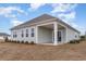 Backyard view of the home featuring a covered porch and well-manicured landscaping at 7367 Meadow Walk Loop, Loris, SC 29569