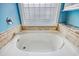 Close up shot of a clean white bathtub with a window and shelves in the background of the picture at 78 Saltwind Loop, Murrells Inlet, SC 29576