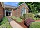 Detailed view of a brick home entrance showcasing landscaped flower beds and sidewalk path at 78 Saltwind Loop, Murrells Inlet, SC 29576