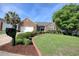 Beautifully landscaped brick home featuring a lush green lawn and mature trees at 78 Saltwind Loop, Murrells Inlet, SC 29576