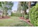 Landscaped front yard with mature trees, hedges, green grass, a mulch bed, and a brick border at 78 Saltwind Loop, Murrells Inlet, SC 29576