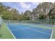 Outdoor pickleball courts surrounded by tall trees and a green fence under a partially cloudy sky at 78 Saltwind Loop, Murrells Inlet, SC 29576