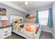 Bright bedroom features a ceiling fan, colorful bedding, artwork, and natural light from the window at 8887 Chandler Dr. # A, Myrtle Beach, SC 29575