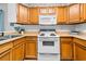 Bright kitchen featuring wooden cabinets and white appliances, ready for cooking at 9501 Shore Dr. # C-328, Myrtle Beach, SC 29572