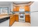 Well-lit kitchen with wooden cabinets, white appliances, and neutral countertops at 9501 Shore Dr. # C-328, Myrtle Beach, SC 29572