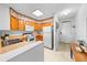 Compact kitchen with wooden cabinets, white appliances, and a cozy breakfast bar at 9501 Shore Dr. # C-328, Myrtle Beach, SC 29572
