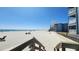 View of beach with people, the ocean, and condo buildings from the top of a wooden staircase at 9540 Shore Dr. # 1N, Myrtle Beach, SC 29572