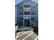 Three-story condominium building featuring blue siding, white railings, palm trees, and convenient parking at 9540 Shore Dr. # 1N, Myrtle Beach, SC 29572