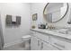 Well-lit bathroom featuring a white vanity with granite countertop and a round mirror at 1010 Graybill Lane, North Myrtle Beach, SC 29582
