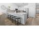 Open kitchen with white cabinets, large island with seating, and hardwood floors at 1010 Graybill Lane, North Myrtle Beach, SC 29582