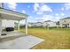 Large backyard with a well-maintained lawn, covered patio, and black metal fence at 1015 Saltgrass Way, Myrtle Beach, SC 29588