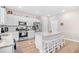Bright kitchen featuring white cabinets, stainless steel appliances, and a granite island with stool seating at 1015 Saltgrass Way, Myrtle Beach, SC 29588