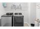 Well-lit laundry room with modern washer and dryer units and overhead storage shelf at 1015 Saltgrass Way, Myrtle Beach, SC 29588