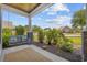 Inviting front porch with a porch swing, stone columns, a wooden ceiling, and a well-maintained garden at 1028 Whooping Crane Dr., Conway, SC 29526
