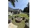 Spacious backyard with a unique fire pit area, surrounded by log seating, and a tranquil setting at 113 Edwards Ln., Longs, SC 29568