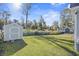 Large, grassy backyard featuring a storage shed and mature trees at 113 Edwards Ln., Longs, SC 29568