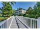 Three story building with beautiful landscaping, overlooking a serene pond with a connecting bridge at 116 Cypress Point Ct. # 302, Myrtle Beach, SC 29579