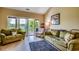 Inviting living room featuring comfortable green couches, stylish rug, and a scenic balcony view at 116 Cypress Point Ct. # 302, Myrtle Beach, SC 29579