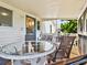 Charming covered porch with a glass-top table and ample seating, perfect for relaxing and entertaining guests at 118 Seaside St., Holden Beach, NC 28462