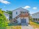 Charming white beach house with gray garage and a wooden staircase leading to a cozy deck at 118 Seaside St., Holden Beach, NC 28462