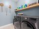 Well-equipped laundry room featuring modern washer and dryer with shelf storage above at 127 Emerald Rush Ct., Longs, SC 29568