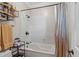 A bathtub with shower features black fixtures, a rack for storage, and a neutral striped curtain at 130 Pier Pointe Dr., Little River, SC 29566
