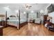 Spacious bedroom with four-poster bed, sitting area, and hardwood floors at 130 Pier Pointe Dr., Little River, SC 29566