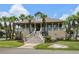 Stately two-story home with a grand staircase, full front porch, and lush landscaping with mature palm trees at 130 Pier Pointe Dr., Little River, SC 29566