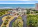Aerial view of an oceanfront community, showcasing the clubhouse, pool, beach access, and well-manicured landscaping at 1330 Villa Marbella Ct. # 3-105, Myrtle Beach, SC 29572