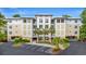 Exterior view of the condo featuring a well-maintained building and inviting entrance with palm trees at 1330 Villa Marbella Ct. # 3-105, Myrtle Beach, SC 29572