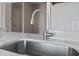 Close-up of a modern stainless steel kitchen sink and faucet against a white countertop at 1391 Turkey Ridge Rd. # C, Surfside Beach, SC 29575