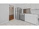 Galley kitchen with white cabinets, stainless steel appliances, and tile flooring at 1391 Turkey Ridge Rd. # C, Surfside Beach, SC 29575