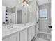 Bright bathroom with double sink vanity, a large mirror, and a tiled shower at 140 Zinnia Dr., Myrtle Beach, SC 29579