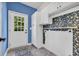Laundry room featuring a door to the backyard, storage cabinets, and vibrant wallpaper at 140 Zinnia Dr., Myrtle Beach, SC 29579