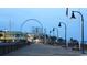 Evening view of a lit boardwalk with shops, a Ferris wheel, and an American flag at 1501 S Ocean Blvd. # 1107, Myrtle Beach, SC 29577